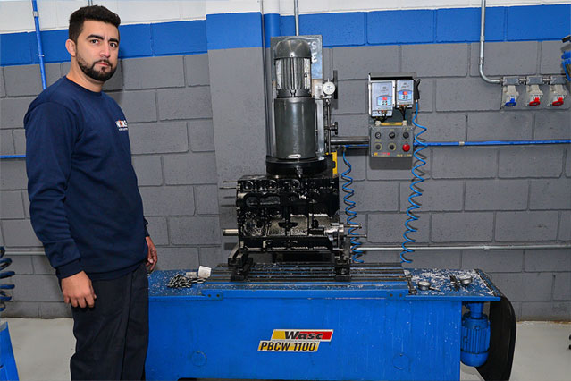 Técnico de motores mostrando o funcionamento de um equipamento da retífica de motores Nobre