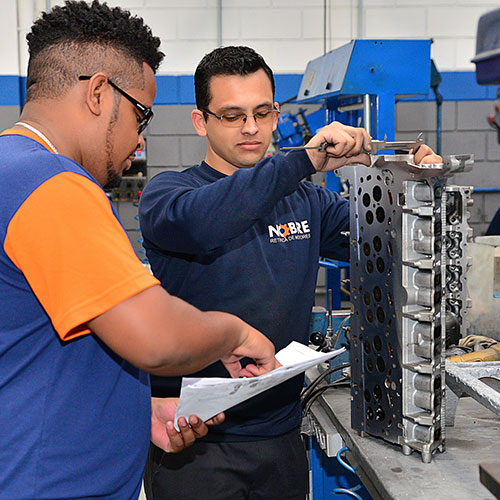 técnico inspecionando peças de motor na retífica de motores NOBRE